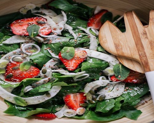 A vibrant bowl of fresh salad with mixed vegetables and seeds