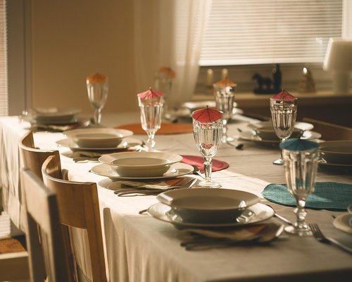 A wooden dining table set with various sharing plates and warm lighting