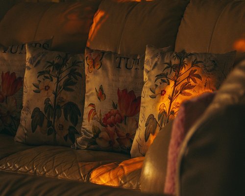 A cozy evening living room setup with warm lamp light and folded blankets